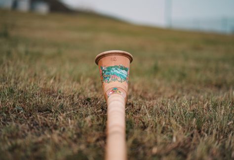 white and brown disposable cup on green grass during daytime